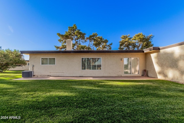 back of house with a lawn, central air condition unit, and a patio