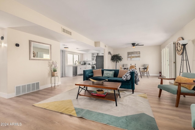 living room featuring light wood-type flooring and ceiling fan