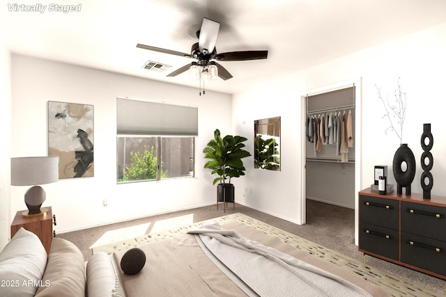 bedroom featuring carpet floors, baseboards, visible vents, and a walk in closet