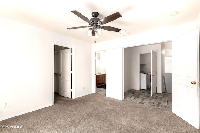 unfurnished bedroom featuring visible vents, washing machine and dryer, baseboards, a spacious closet, and carpet flooring