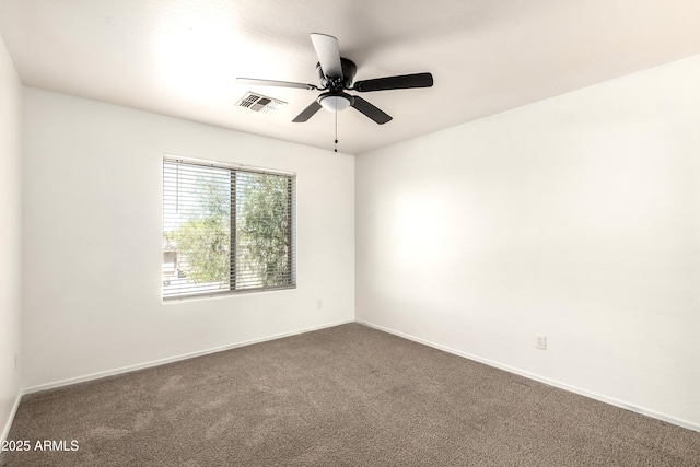 empty room featuring baseboards, a ceiling fan, dark colored carpet, and visible vents