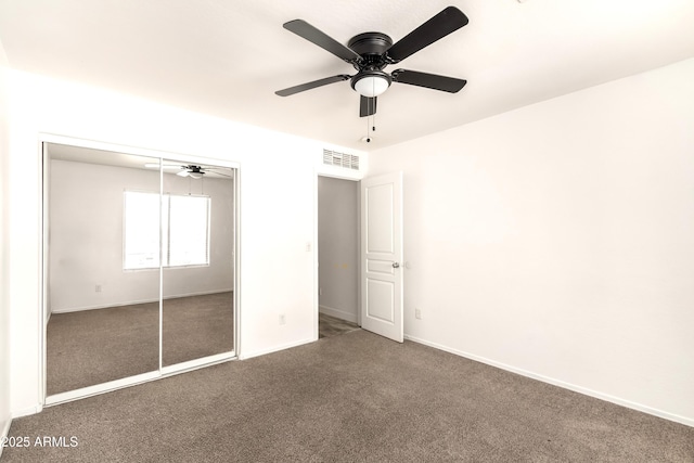 unfurnished bedroom featuring visible vents, carpet floors, a closet, baseboards, and ceiling fan
