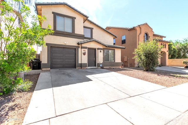 view of front of property with an attached garage, stucco siding, driveway, and a tile roof