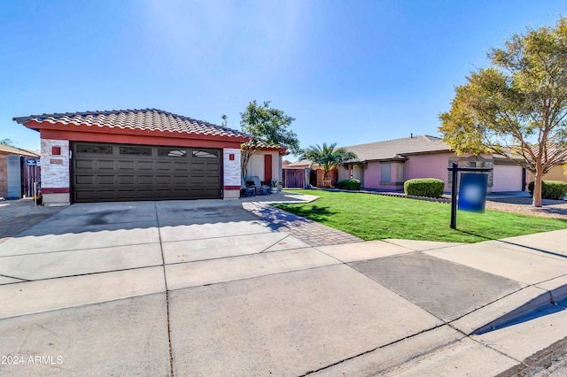 view of front of home with a front yard and a garage