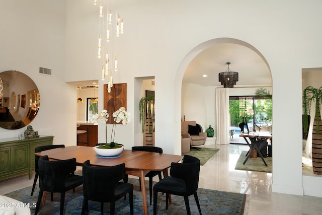 8332 E San Simon Dr, Scottsdale, AZ 85258 - dining room featuring an inviting chandelier, a high ceiling, visible vents, arched walkways, and marble finish floor