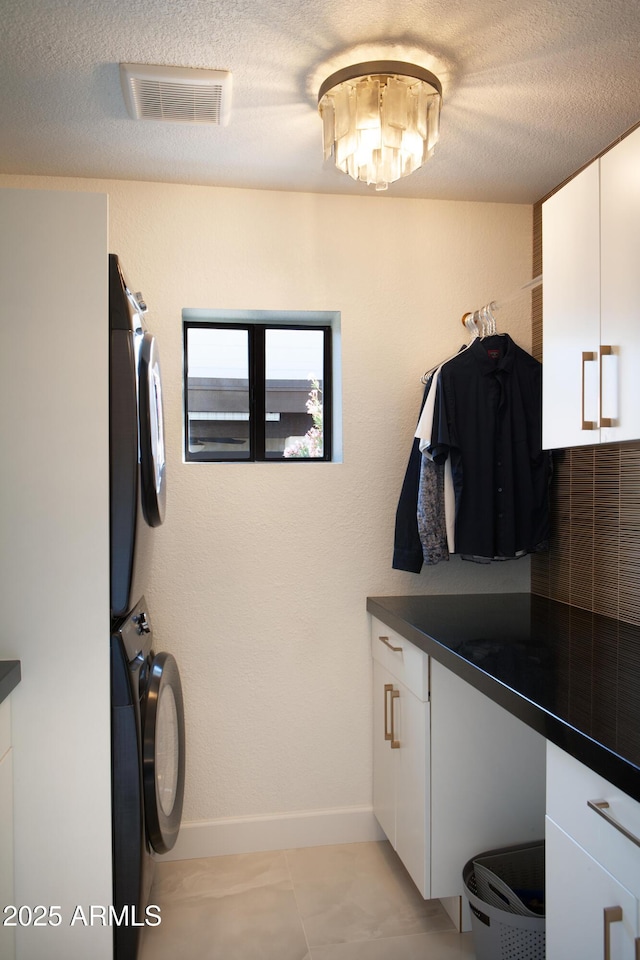 8332 E San Simon Dr, Scottsdale, AZ 85258 - laundry room with a textured ceiling, cabinet space, and stacked washer / drying machine