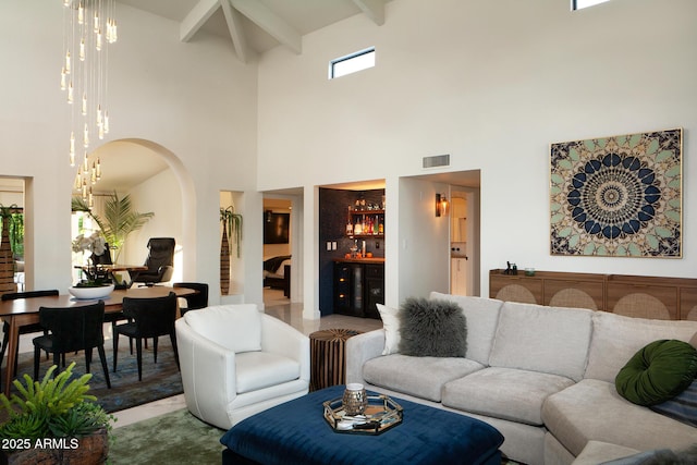 8332 E San Simon Dr, Scottsdale, AZ 85258 - living area featuring visible vents, arched walkways, a high ceiling, a chandelier, and beamed ceiling