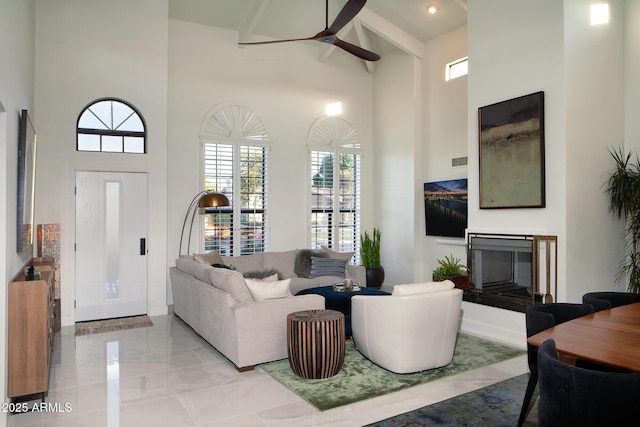 8332 E San Simon Dr, Scottsdale, AZ 85258 - living room featuring ceiling fan, a towering ceiling, a glass covered fireplace, visible vents, and marble finish floor