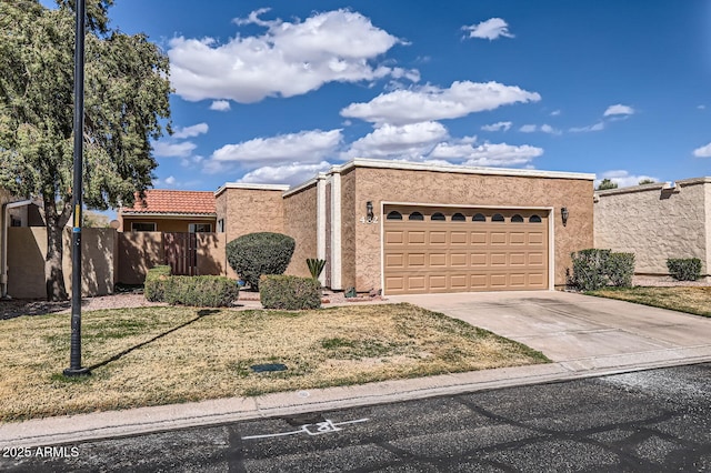 view of front of home featuring driveway, an attached garage, fence, and stucco siding