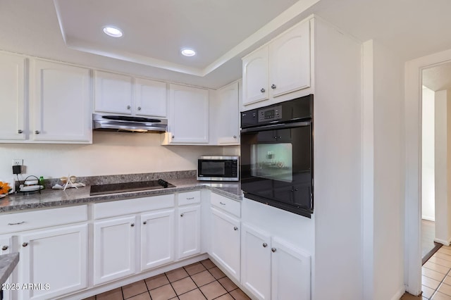 kitchen with light tile patterned floors, black appliances, ventilation hood, and white cabinets