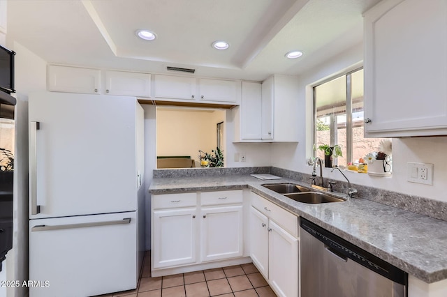 kitchen with recessed lighting, a raised ceiling, freestanding refrigerator, a sink, and dishwasher