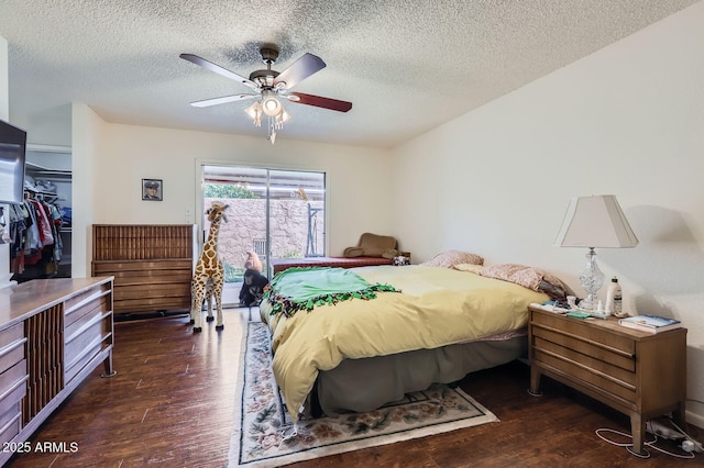 bedroom with a textured ceiling, ceiling fan, a closet, and wood finished floors