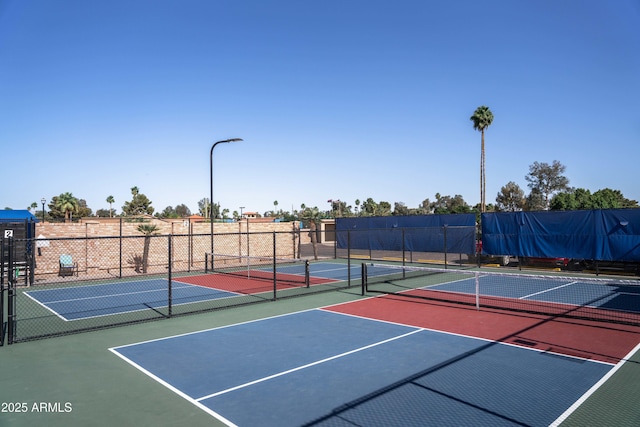 view of tennis court featuring fence