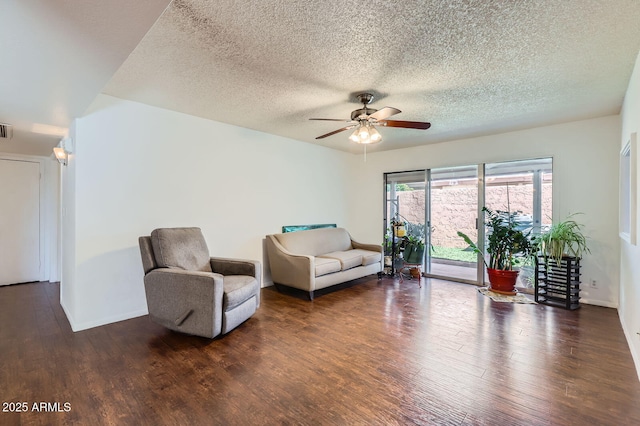 living room featuring baseboards, visible vents, a ceiling fan, wood finished floors, and a textured ceiling