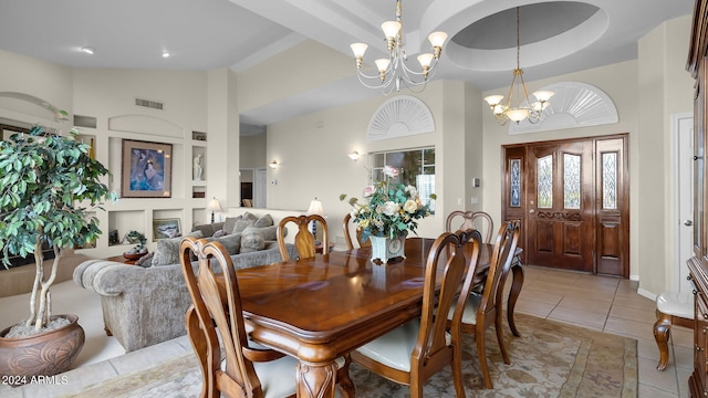 tiled dining room featuring an inviting chandelier and a high ceiling