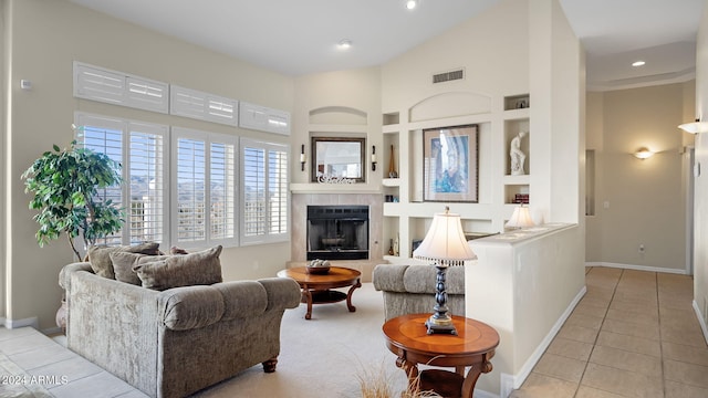 tiled living room featuring high vaulted ceiling, a fireplace, and built in features