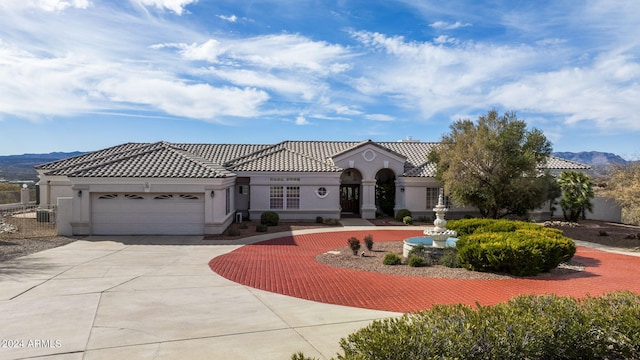 mediterranean / spanish-style house with a mountain view and a garage