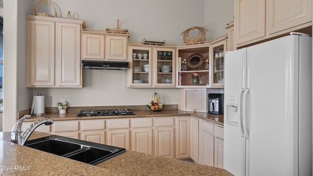 kitchen with white fridge with ice dispenser, light stone counters, sink, black gas stovetop, and cream cabinets