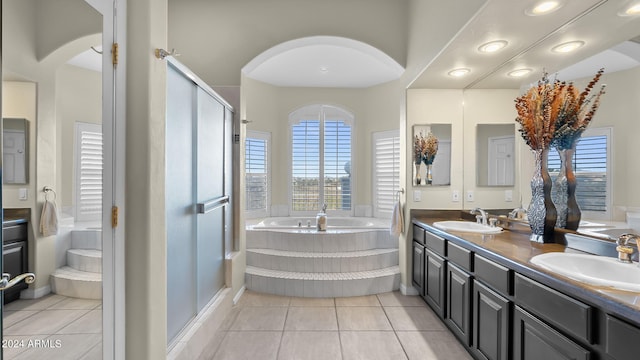 bathroom with tile patterned flooring, independent shower and bath, and vanity