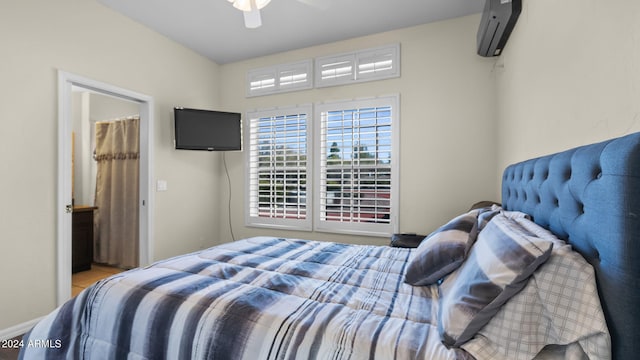 bedroom with ceiling fan and a wall unit AC