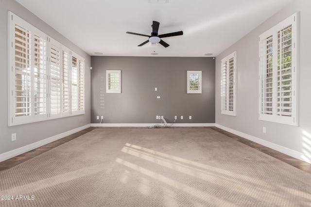 carpeted empty room featuring a wealth of natural light and ceiling fan