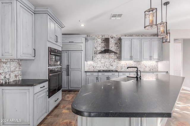 kitchen featuring wall chimney range hood, a sink, dark countertops, backsplash, and recessed lighting