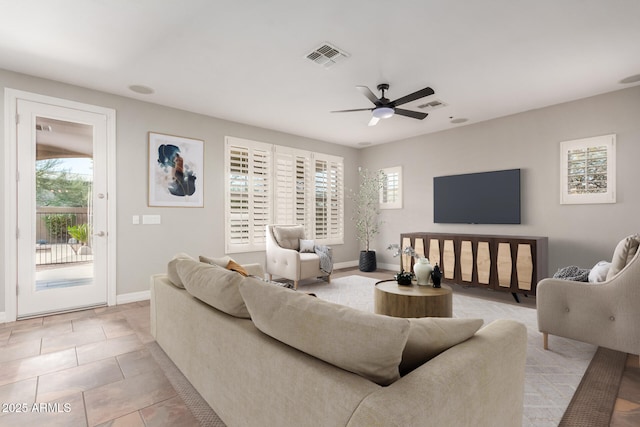 tiled living room featuring ceiling fan and baseboards