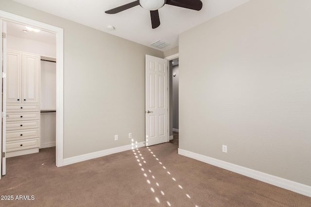 unfurnished bedroom with carpet flooring, a closet, baseboards, and a ceiling fan