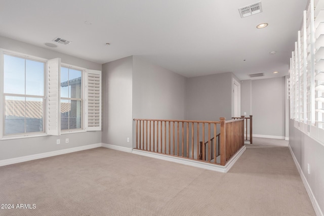 carpeted empty room featuring healthy amount of natural light, recessed lighting, and baseboards