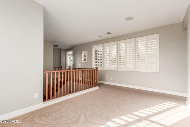 unfurnished room with carpet and baseboards