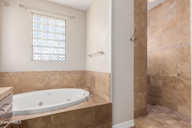 bathroom featuring vanity, a tile shower, and a whirlpool tub