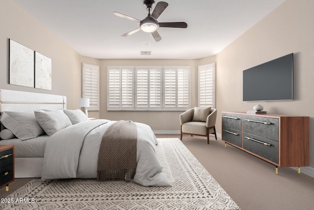 bedroom featuring baseboards, light colored carpet, and ceiling fan