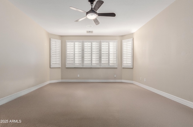 carpeted empty room featuring a ceiling fan and baseboards