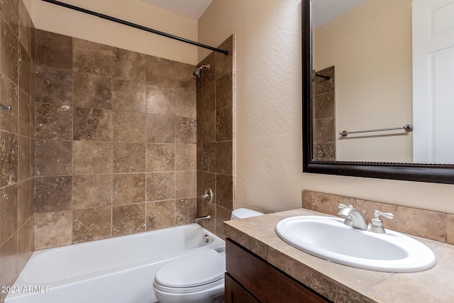 full bath with a textured wall, toilet, bathing tub / shower combination, and vanity