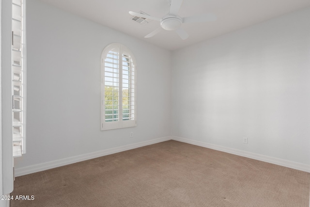 unfurnished room featuring visible vents, carpet floors, baseboards, and ceiling fan