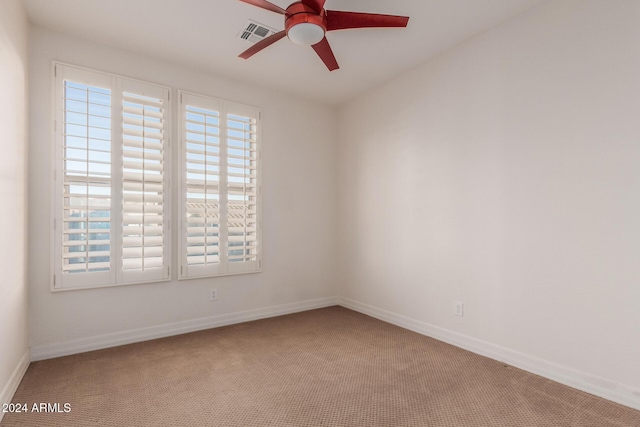 spare room featuring carpet floors, a ceiling fan, and baseboards