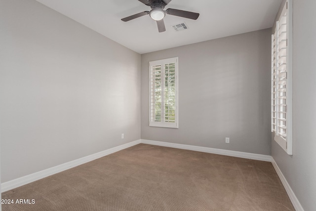 carpeted spare room featuring ceiling fan