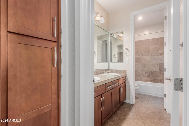 full bathroom with toilet, tiled shower / bath combo, vanity, and tile patterned flooring