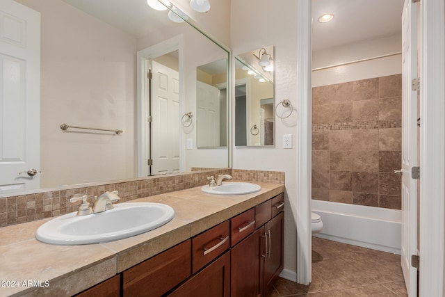 full bathroom with toilet, tile patterned floors, tiled shower / bath, vanity, and backsplash