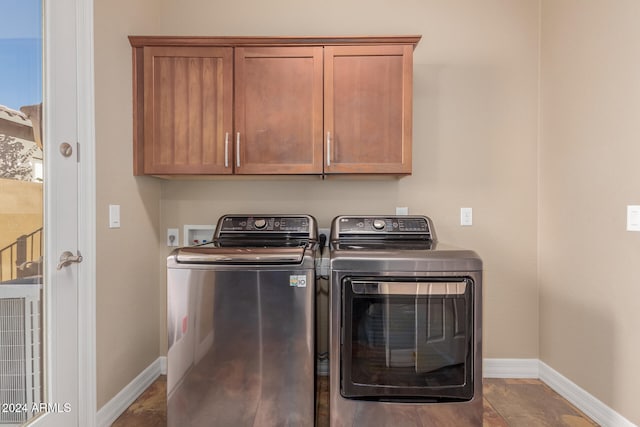 clothes washing area with cabinets and washer and clothes dryer