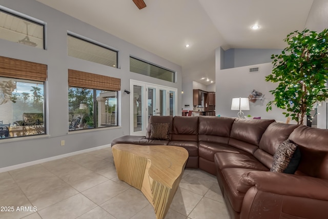 living area with light tile patterned floors, baseboards, visible vents, french doors, and high vaulted ceiling