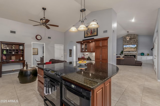 kitchen featuring open floor plan, electric range, light tile patterned flooring, and arched walkways