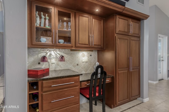 interior space with visible vents, backsplash, baseboards, and light tile patterned floors