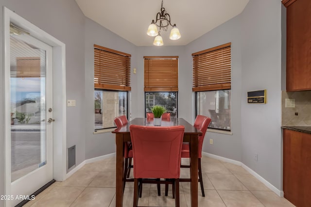 dining room featuring a chandelier, baseboards, and light tile patterned floors