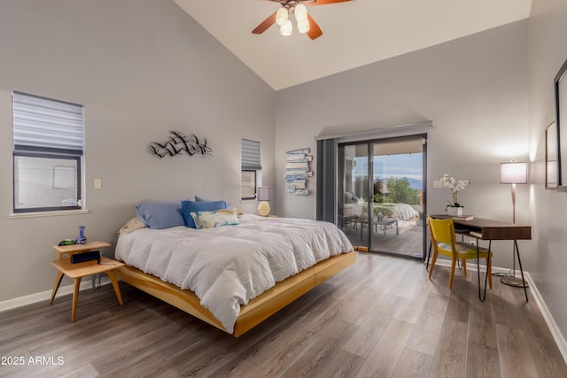 bedroom featuring access to exterior, high vaulted ceiling, baseboards, and wood finished floors