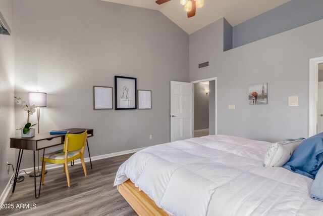 bedroom featuring high vaulted ceiling, baseboards, visible vents, and wood finished floors