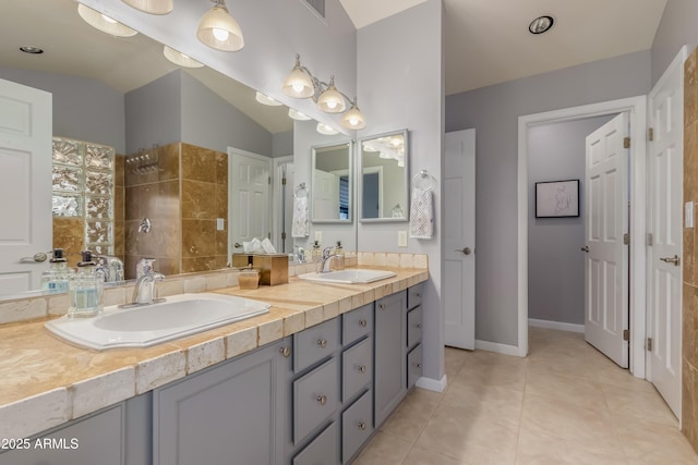 full bathroom with lofted ceiling, a walk in shower, a sink, and tile patterned floors