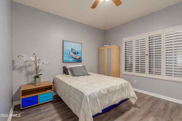 bedroom with ceiling fan, baseboards, and wood finished floors