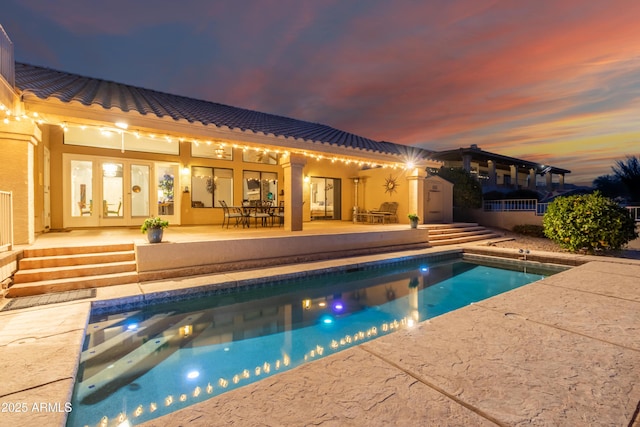 outdoor pool featuring french doors and a patio area