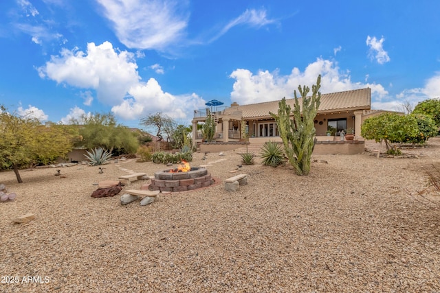 back of property featuring a patio, an outdoor fire pit, a tiled roof, and stucco siding